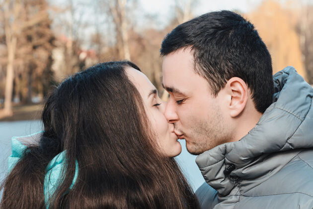 浪漫情侣在日落时分在户外接吻-关于人 爱和生活方式的概念第一次年轻女朋友