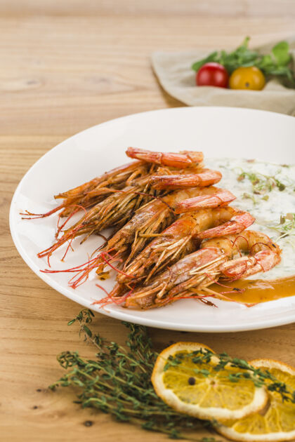 海鲜把奶油大虾放在一个盘子里 放在一个浅色的木头表面上虾木头盘子