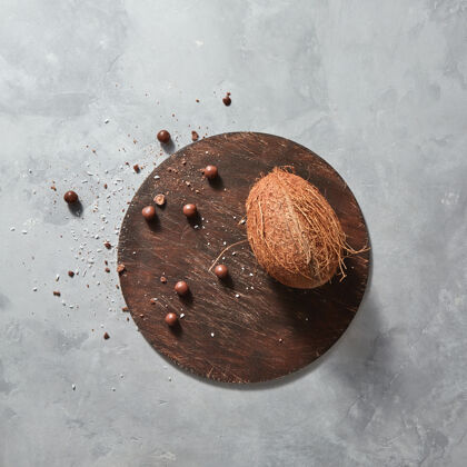 美味热带异国情调的水果椰子巧克力球放在一个灰色的石桌上 放在下面文本.top查看素食者饮食的概念生食一半板