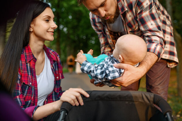 人有爱心的父母带着小宝宝在夏日公园散步健康男人休闲