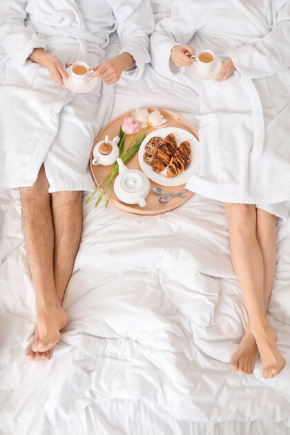 生活方式年轻夫妇在家里床上吃早餐年轻杯子手
