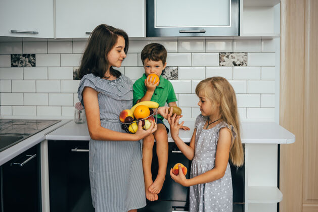 食物健康的概念吃有趣孩子们在厨房里吃水果厨房女孩孩子