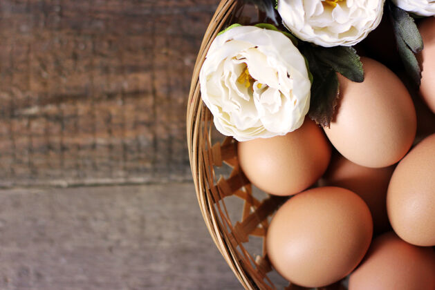 食物鸡蛋和花放在木桌上的篮子里传统鸡蛋早餐