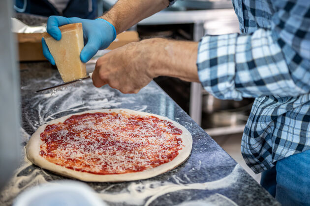 糕点一个男人在当地的披萨和陀螺餐厅做玛格丽塔披萨餐厅番茄面包房