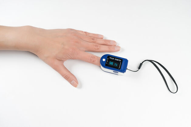 医疗便携式数字指尖脉搏血氧仪在一个女人的手隔离在白色的墙壁上饱和度监测氧气