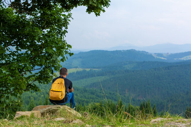 男独自一人坐在悬崖上 享受宁静的青山风景和平放松一下独自山悬崖