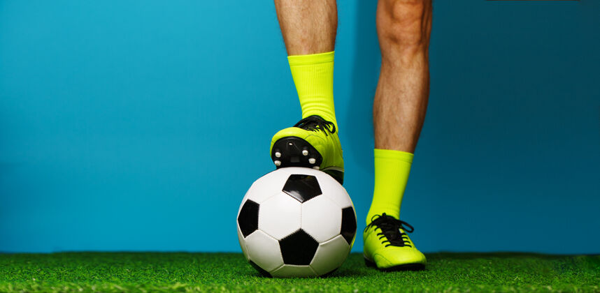 冠军在绿草和蓝色背景上拿球的足球运动员比赛比赛赢家