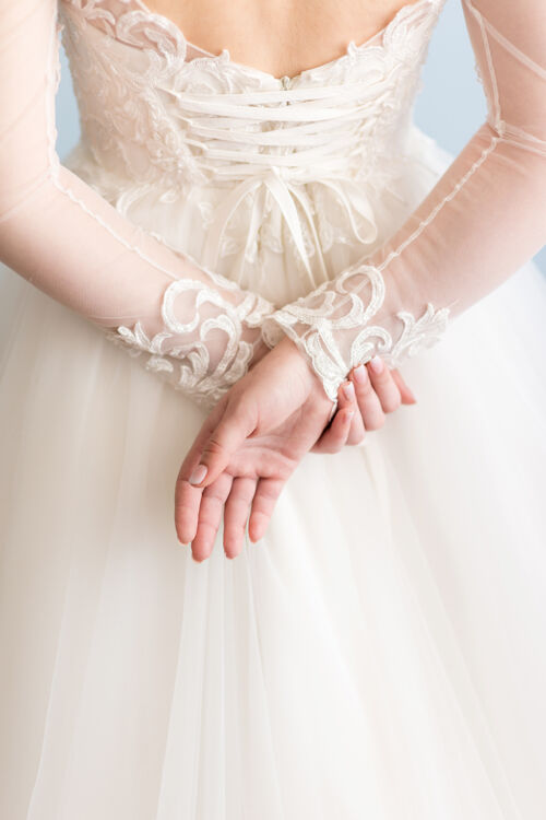 手穿着婚纱的新娘在背后牵手举行背人