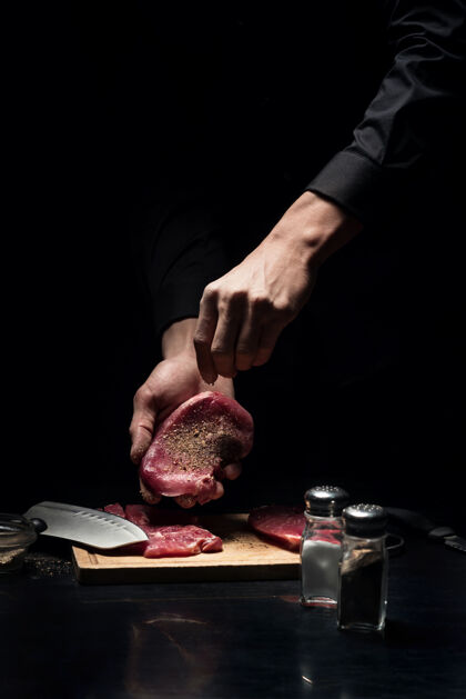 刀调味和美味接近很多年轻的男厨师在餐馆工作和做饭的时候用手在肉上加香料印章对比香料
