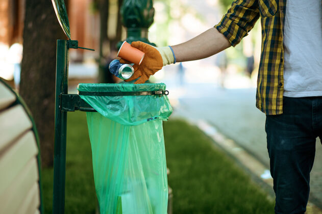 概念年轻人把垃圾放在公园的塑料袋里 志愿服务男人清林 生态修复 生态生活方式 垃圾收集回收 生态关爱 环境清洁生态系统回收挑选