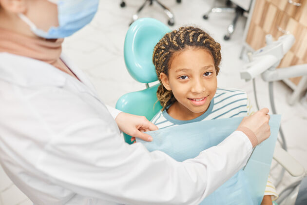 人一张小病人坐在牙科椅上微笑的画像 牙医正在为她准备体检美女表情牙科健康