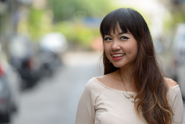 亚洲人年轻美丽的亚洲女商人在城市户外的画像沉思公司女性