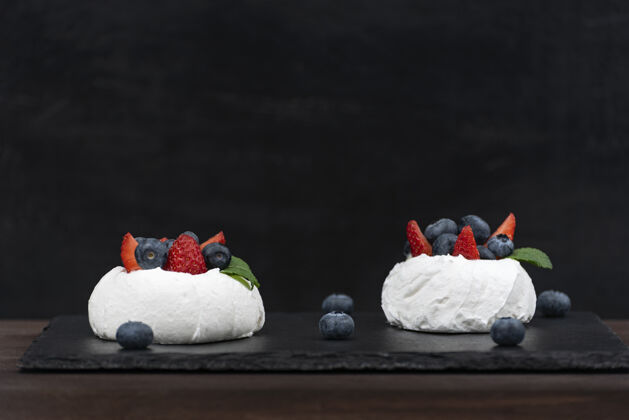甜食黑色安娜巴甫洛娃蛋糕背景空气新鲜草莓蓝莓酥皮蛋糕果皮自制水果