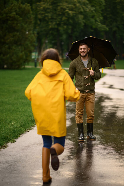 人快乐的爱情情侣在公园约会 夏日多雨戴曼雨伞下的女人 散步路上的浪漫约会 小巷里的潮湿天气一起公园快乐