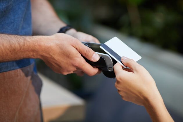 科技女服务员用信用卡刷卡时 服务员拿着支付终端的特写镜头连接咖啡馆支付