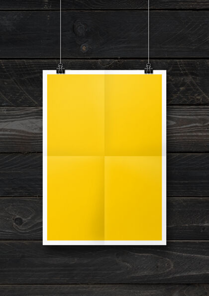 空黄色折叠海报挂在黑色的木墙上与剪辑办公室表黄色