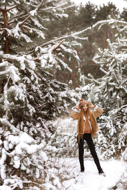 覆盖女孩冬天在树林里散步森林季节雪