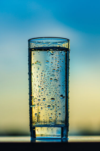 背景一杯饮用水映衬着夕阳的天空水健康透明