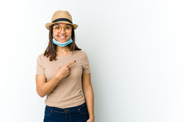微笑年轻的拉丁女人戴着帽子和面具 以防科维德微笑着指着一边 在空白处展示一些东西漂亮手指流行