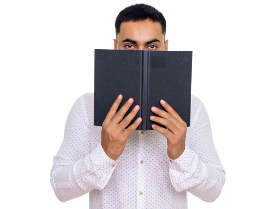 秘密年轻英俊的印度男人躲在书后面 与空白隔离吸引日记印度人