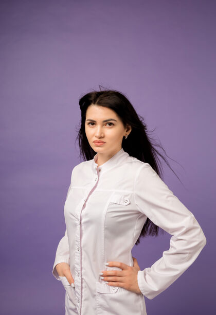 年轻一个穿着白色制服的漂亮女医生的肖像画在紫色的墙上医学专家医学