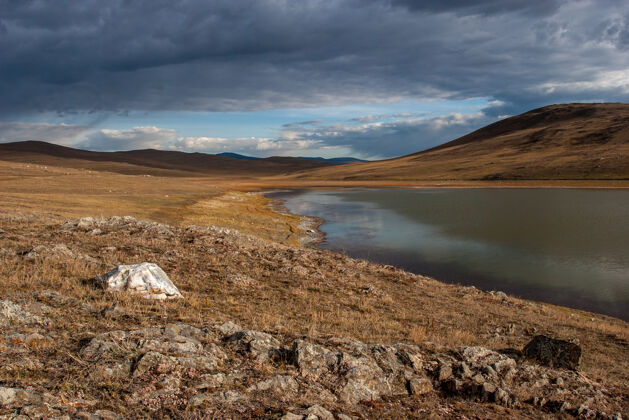 西伯利亚草原湖 前景是石头 远处是小山 天空是云外面草原距离