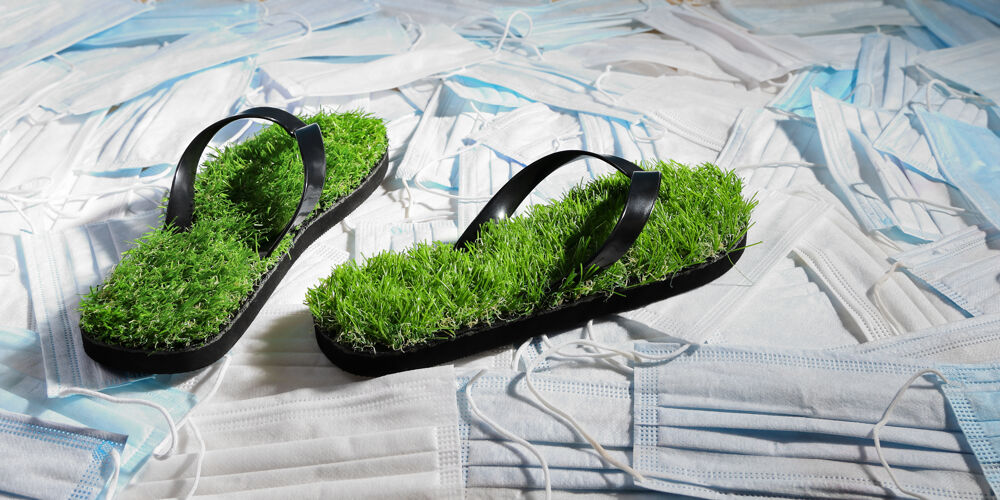 环境绿色的拖鞋 表面有仿草的医用口罩 污染了地球冠状病毒一次性回收