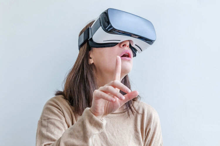 虚拟微笑的年轻女子戴着虚拟现实vr眼镜头盔耳机在白色背景上显示眼镜娱乐