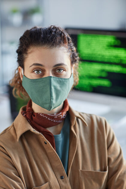 大流行戴着防护面具的年轻女子在办公室工作时注视前方的画像流感病毒流行病成人