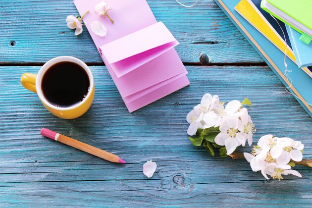 房子打开空白的笔记本和铅笔 一杯咖啡 木桌上的鲜花 春天饮料杯子花