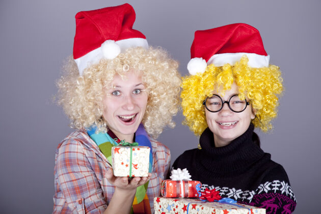 甜蜜两个有趣的女孩过圣诞节礼品工作室射击享受尼斯玩耍