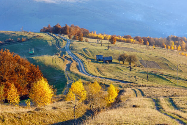 路秋天的山坡上有乡村公路和五颜六色的树木雾蒙蒙的天气风景斜坡秋天
