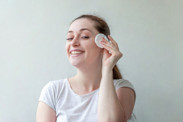 清晰美丽的肖像微笑的女人与柔软健康的皮肤卸妆化妆棉隔离在白色背景上肤色治疗健康