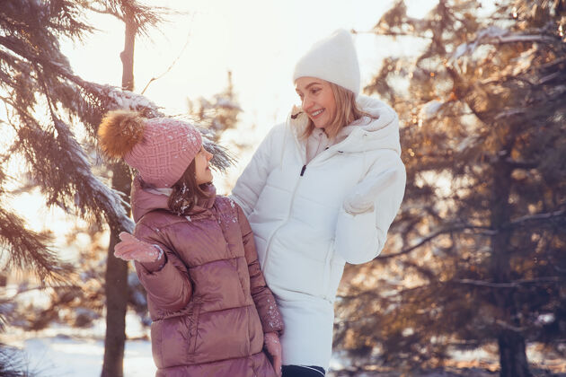 父母妈妈和女儿在冬季公园玩得很开心户外雪散步