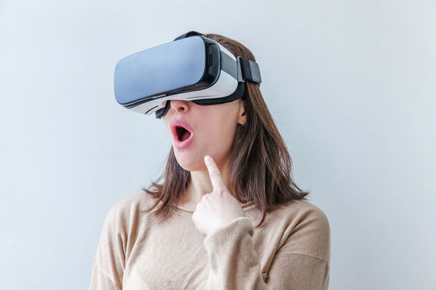 女人微笑的年轻女子戴着虚拟现实vr眼镜头盔耳机在白色背景上虚拟设备创新