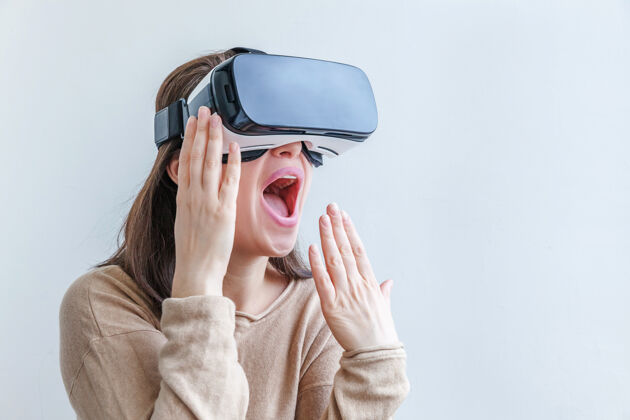 手表微笑的年轻女子戴着虚拟现实vr眼镜头盔耳机在白色背景上创新视觉体验