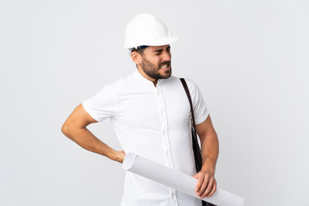 工作戴着头盔 拿着白色背景的设计图的年轻建筑师因为努力而背痛疾病疼痛背痛