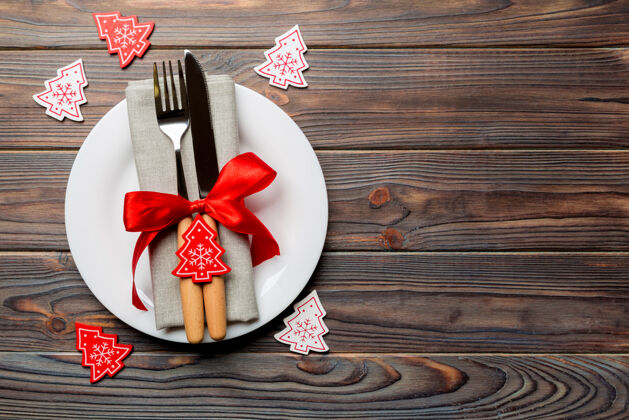 木头圣诞装饰木背景上的盘子 叉子和刀的俯视图叉子餐具圣诞节