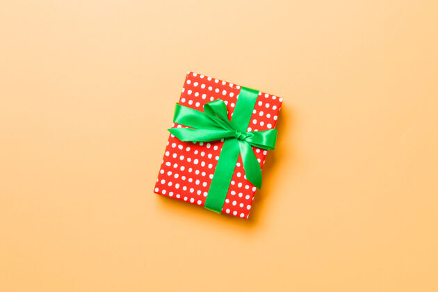 丝带橙色背景的绿色蝴蝶结礼盒赠送包装生日