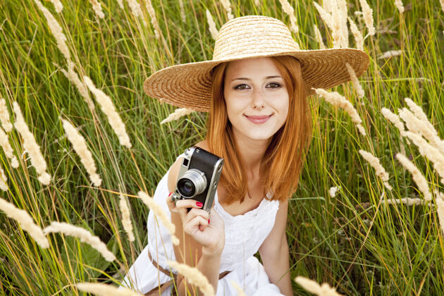 经典在草地上拿着旧相机的红发女孩村庄衣服田野