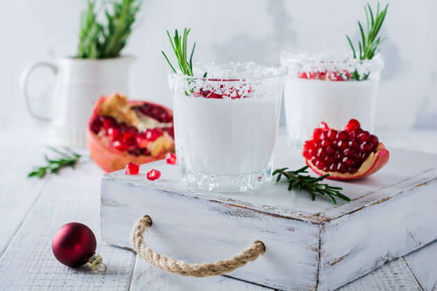 水果圣诞椰子酒配石榴籽和迷迭香小枝 表面光亮起泡核桃玻璃杯