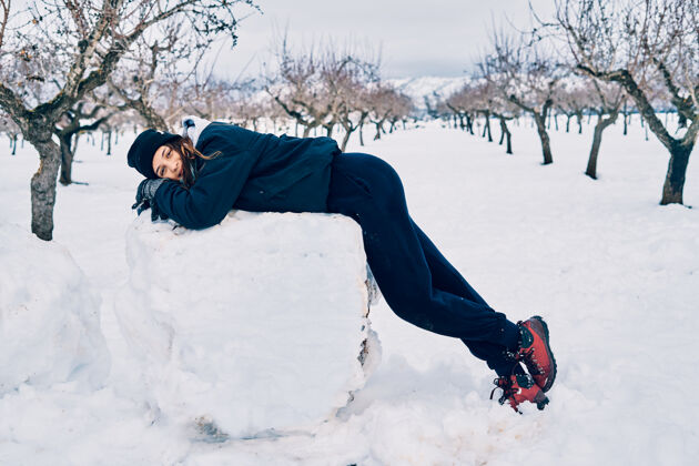 寒冷一幅高加索少女微笑着躺在一个大雪球上的画像年轻户外风景