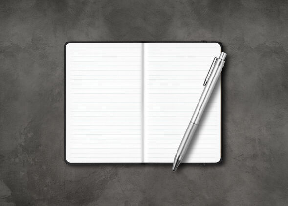 空白黑色的开行笔记本 黑色的水泥背景上有一支笔日记深色打开