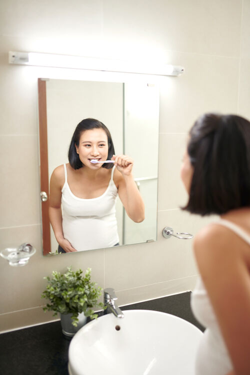 清洁美丽的孕妇在浴室刷牙的画像女性人牙齿
