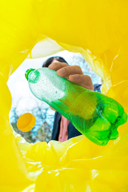 废物把一个绿色塑料瓶扔进垃圾桶的人容器蓝色人