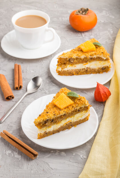 食物自制的柿子南瓜蛋糕和一杯咖啡放在一个灰色的混凝土表面和黄色的纺织品上复制空间黄油糕点