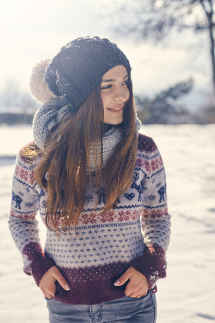 女性美丽的年轻微笑的女人走在阳光明媚的冬天看着远方向上冻结欧洲