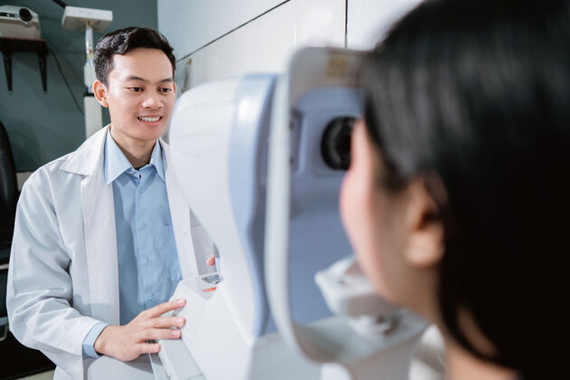 专业一位医生正在眼科诊所用眼科电脑检查一位女病人医学亚洲人男人