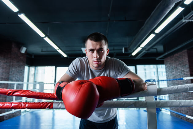 腰部向上强壮的男人英俊强壮的运动员在拳击场上刻苦训练时感到快乐运动员动作拳击圈