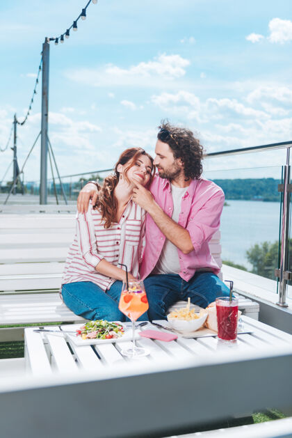 大海浪漫晚餐可爱的时尚情侣在海景露台上享受美妙的浪漫晚餐杯子交流尊重